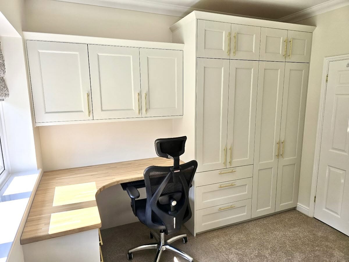 Crowthorne home office with cream painted fitted cabinetry, oak desk top and brass handles