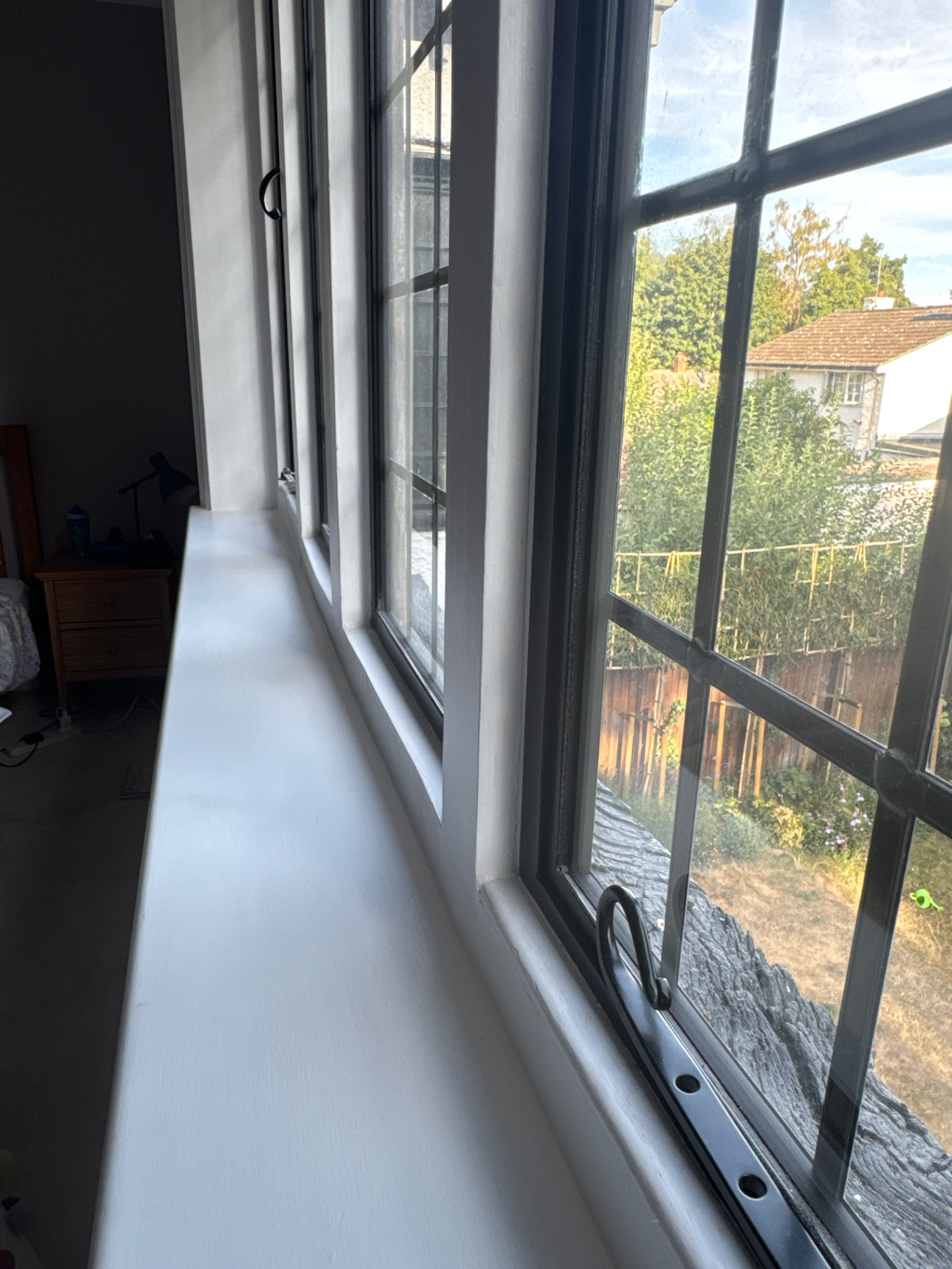 Newly painted window cill and reveals running the length of a leaded window in a Fleet bedroom